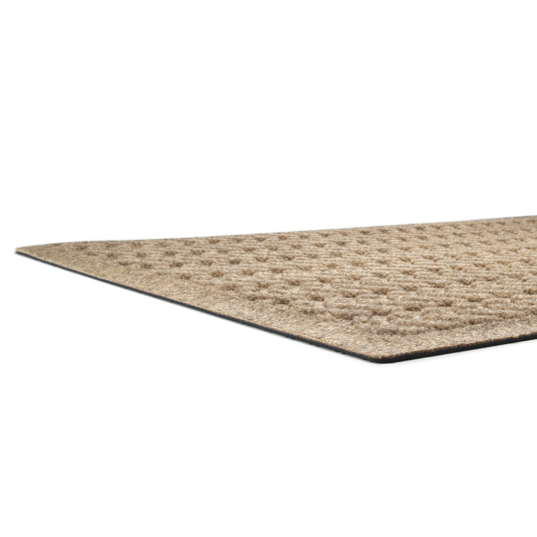 A low and close shot of the Sentry WaterHog doormat's no snag, low-profile, bi-level surface and durable rubber backing.