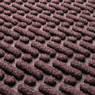 Close-up of the durable WaterHog fibers made of deep wine red, white, and grey fibers pressed to make a geometrical design.