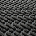 Blown-up view of the eco-friendly WaterHog surface fibers made of various shades of grey to black, with hints of white fibers.