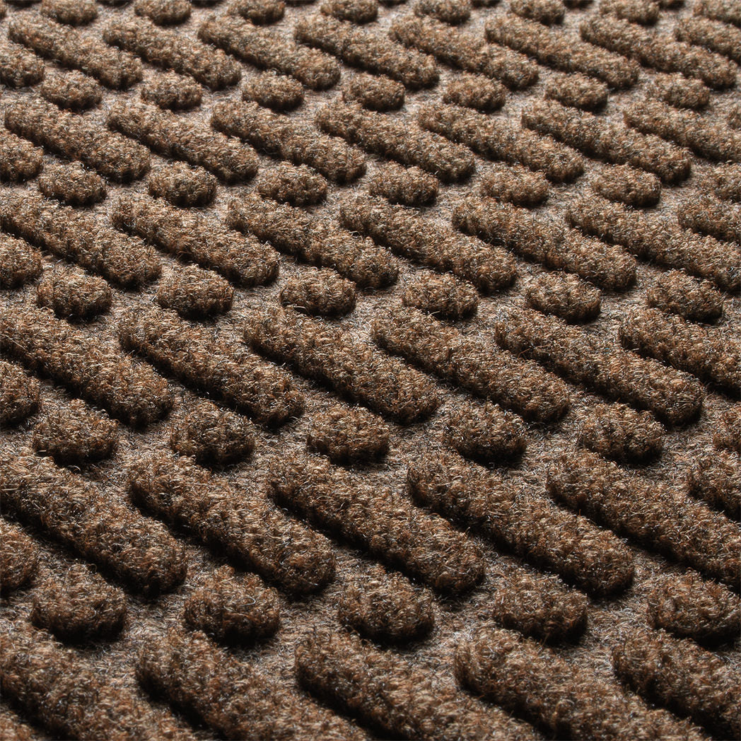 Close-up of the stain-resistant WaterHog surface fibers made of light and dark brown, white, and black fibers.