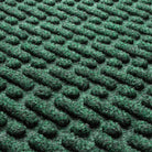 Detail shot of Sentry WaterHog door mat with fibers made up of green, white, and grey creating a geometric design.