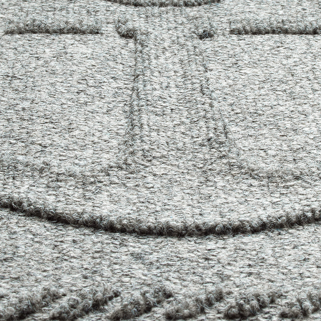 A zoomed-in shot of the WaterHog Ship's Anchor durable doormat in light grey, showcasing the raised design composed of carpeted fibers.