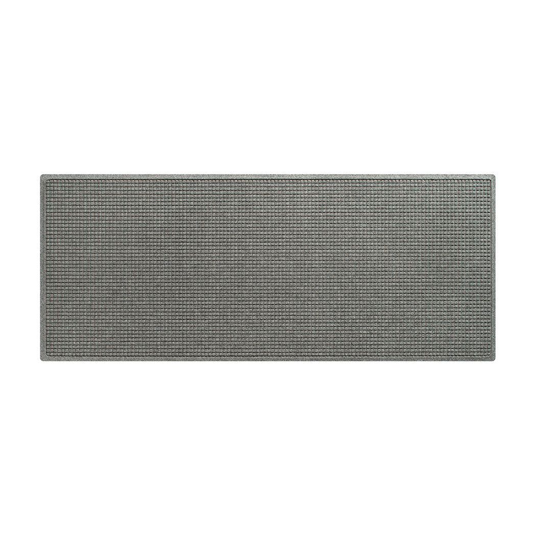 A WaterHog Squares runner made with an eco-friendly surface and backed by durable rubber, shown in light grey.