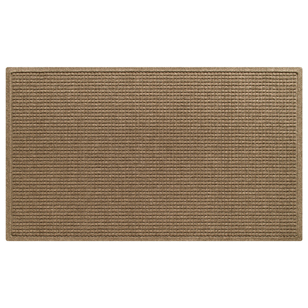 Overhead of a extra large WH Squares indoor/outdoor doormat in a light tan color and uniform grid, bi-level design.