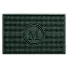 An overhead of a WaterHog Squares doormat monogrammed with an M in the center with a circle around it, shown in a deep green durable surface.