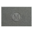 Overhead of a WaterHog Squares all-weather doormat monogrammed with the letter M in a light grey, fade-resistant surface, backed by durable rubber.