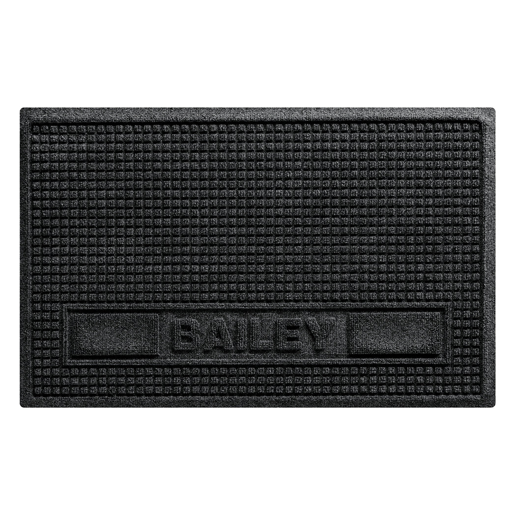 Overhead of a large WaterHog Sqaures pet mat personalized with an all-caps Bailey in the lower center of the mat, with two medium rectangular blocks on the side, in a dark grey, eco-friendly surface.