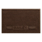 Overhead of a large WaterHog Sqaures pet mat personalized with the name Bailey in all caps in the lower center of the mat, with two medium rectangular blocks on the side, in a dark earthy brown surface.