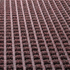 Close-up of WaterHog square's surface recycled eco-friendly fibers made of deep wine reds, whites, and greys, pressed to make a classic design.