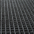 Close-up of WaterHog eco-friendly PET surface fibers in classic squares bi-level pattern made of various shades of grey to black, with hints of white PET fibers.