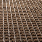 Detailed shot of the stain-resistant WaterHog surface made of light and dark brown, white, and black PET fibers pressed into a bi-level repeating squares original design.