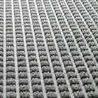 Close-up of WaterHog squares mat fade-resistant recycled PET surface on a light grey, long-lasting doormat with rubber backing.