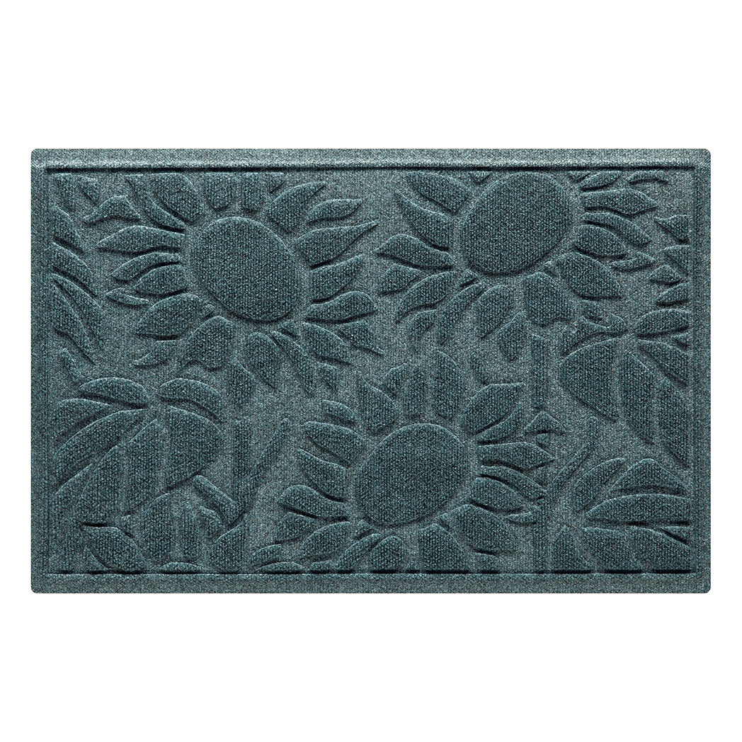 An overhead image of a single-door WaterHog Sunshine Day cute doormat, which features a bi-level design of three sunflowers surrounded by leaves, made to help protect against tracking of mud, dirt, or moisture throughout your home.