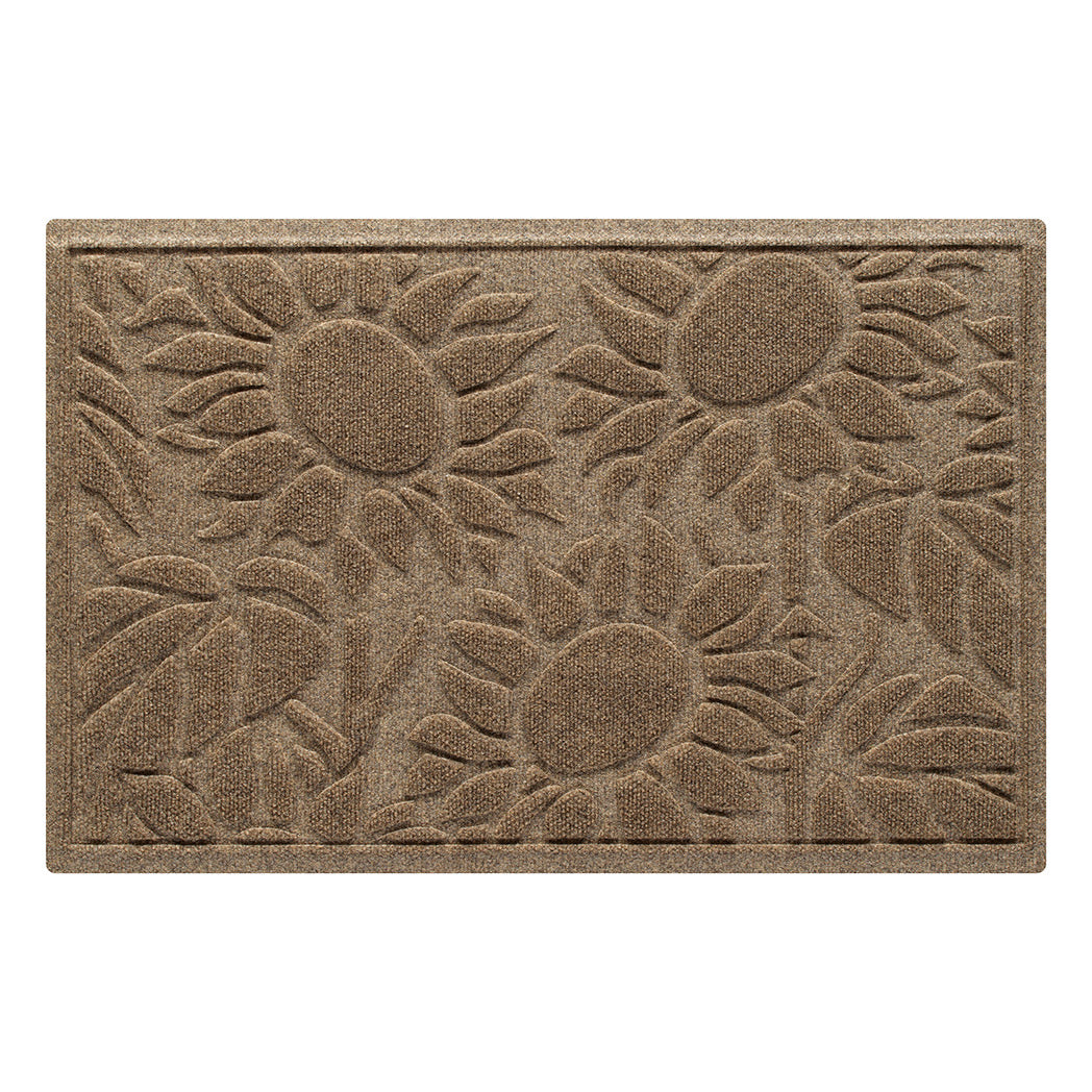 A WaterHog Sunshine Day doormat featuring a sunflower design with three large sunflowers, surrounded by leaves and stems in the color camel, shown on a white background.