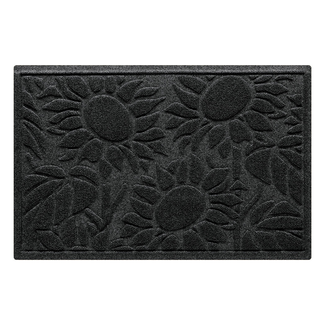 A medium WaterHog Sunshine Day indoor/outdoor doormat that features three giant sunflowers that are surrounded by leaves in a deep, dark grey color.