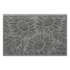 An overhead view of a medium WaterHog Sunshine Day indoor/outdoor doormat in a soft, neutral grey that features the three staggered sunflowers decorated by big leaves, shown on a white background.