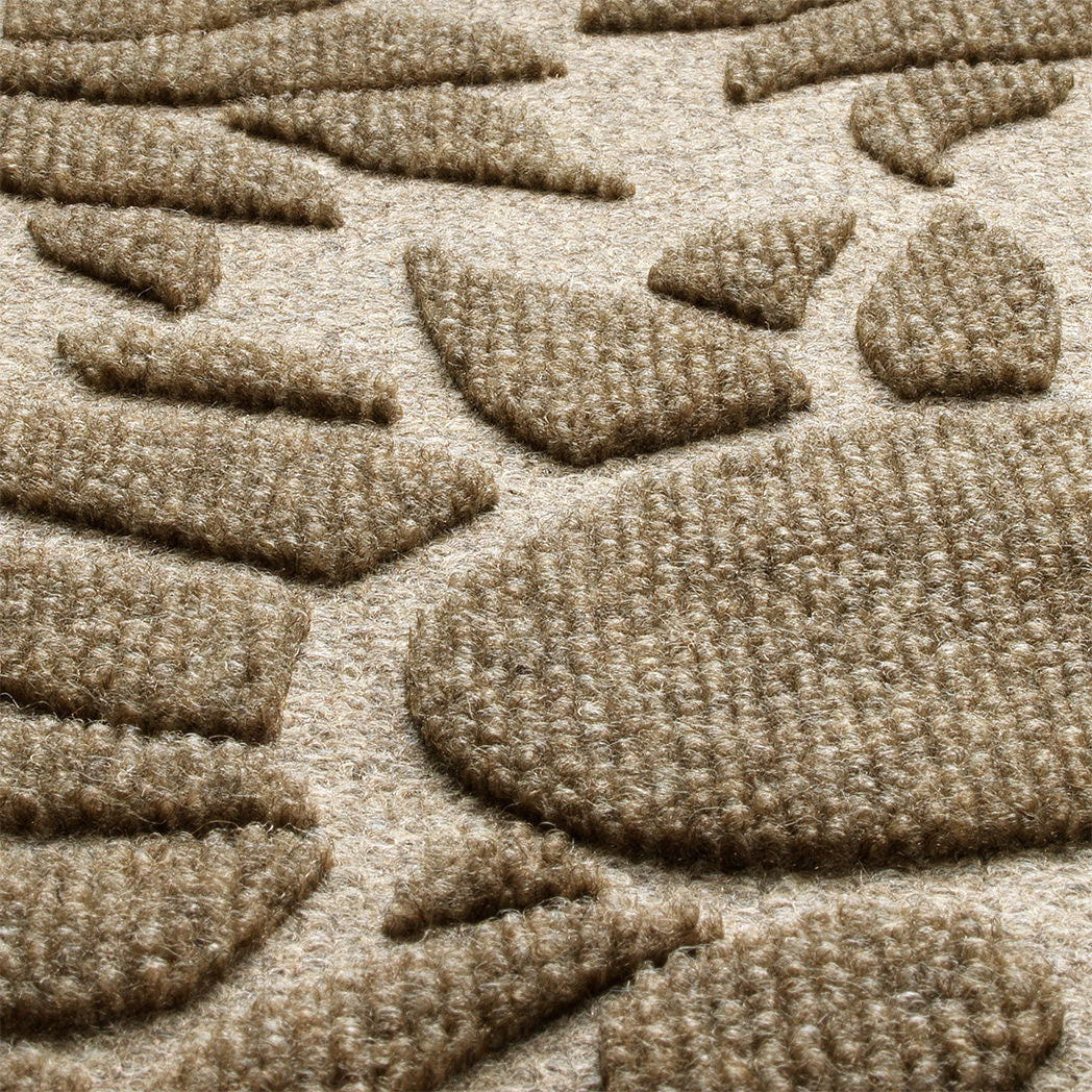 A detailed shot of WaterHog's Sunshine Day doormat's bi-level surface, showing the eco-friendly fibers of various tans, yellows, and whites, blending to make a fade and stain-resistant camel color.