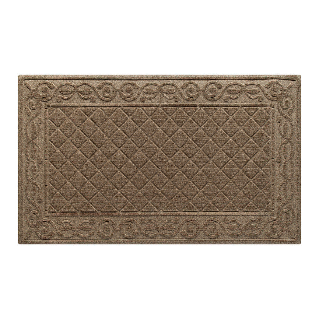 An overhead of a WaterHog Tristan large doormat in the tan camel color with a bi-level design of diamond pattern bordered by an elegant scroll design for scraping and trapping dirt and moisture from off your shoes and your floors.