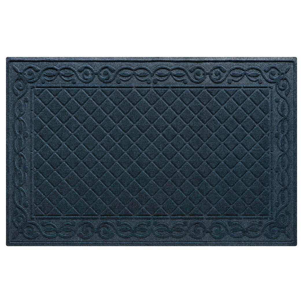 An XL WaterHog Tristan doormat in navy with a two-part bi-level design for dirt and moisture scraping and trapping - a diamond pattern that is surrendered by an ornate scroll design.