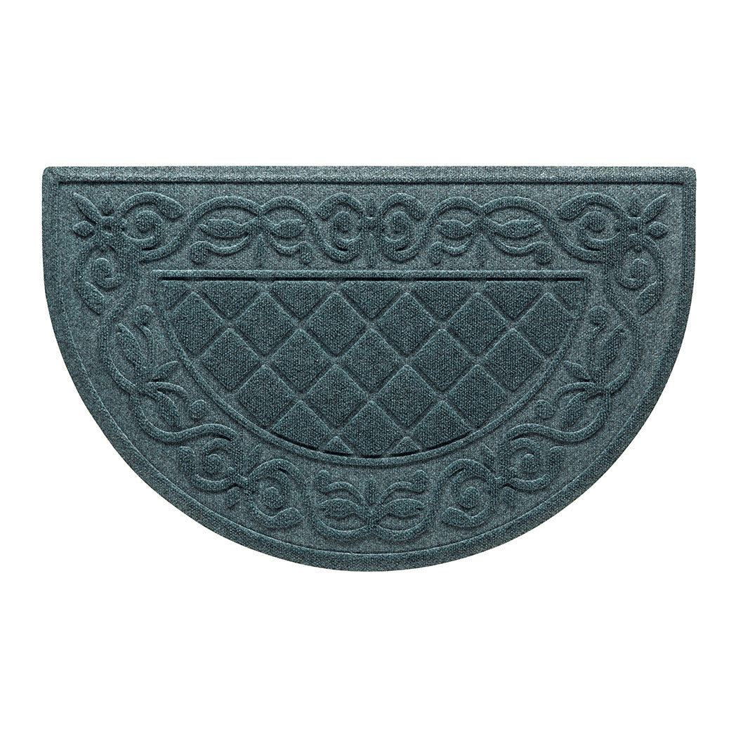 An overhead of a Tristan Half-Round doormat in a dusty light blue that features the design of the classic diamond that is boarded by an ornate scroll design, all encased by a water dam border for holding water off your floors.