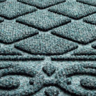 Extreme close-up of the Tristan doormat's aggressively scraping surface fibers, made from recycled plastic fibers - white, greys, blue, and turquoise - creating a muted light blue color.