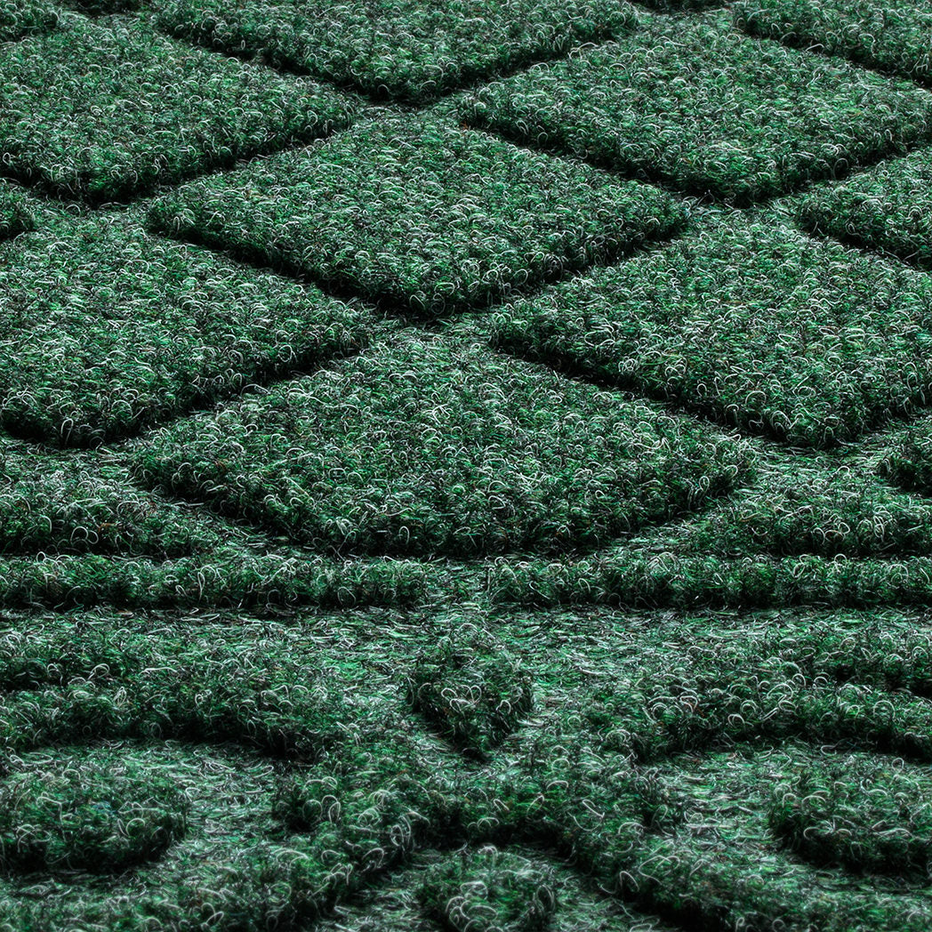 A close-up of Tristan's bi-level doormat surface engineered for aggressive scrapping and trapping dirt and moisture, shown in the color forest green.