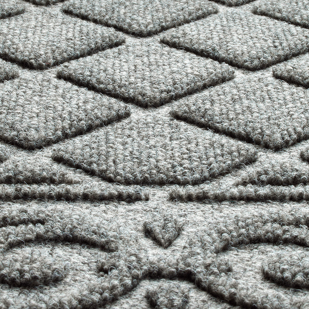 Extreme close-up of the Tristan doormat's eco-friendly surface fibers, made from recycled plastic fibers - white, greys, and blacks - creating a soft and neutral medium grey color that is fade and stain-resistant.