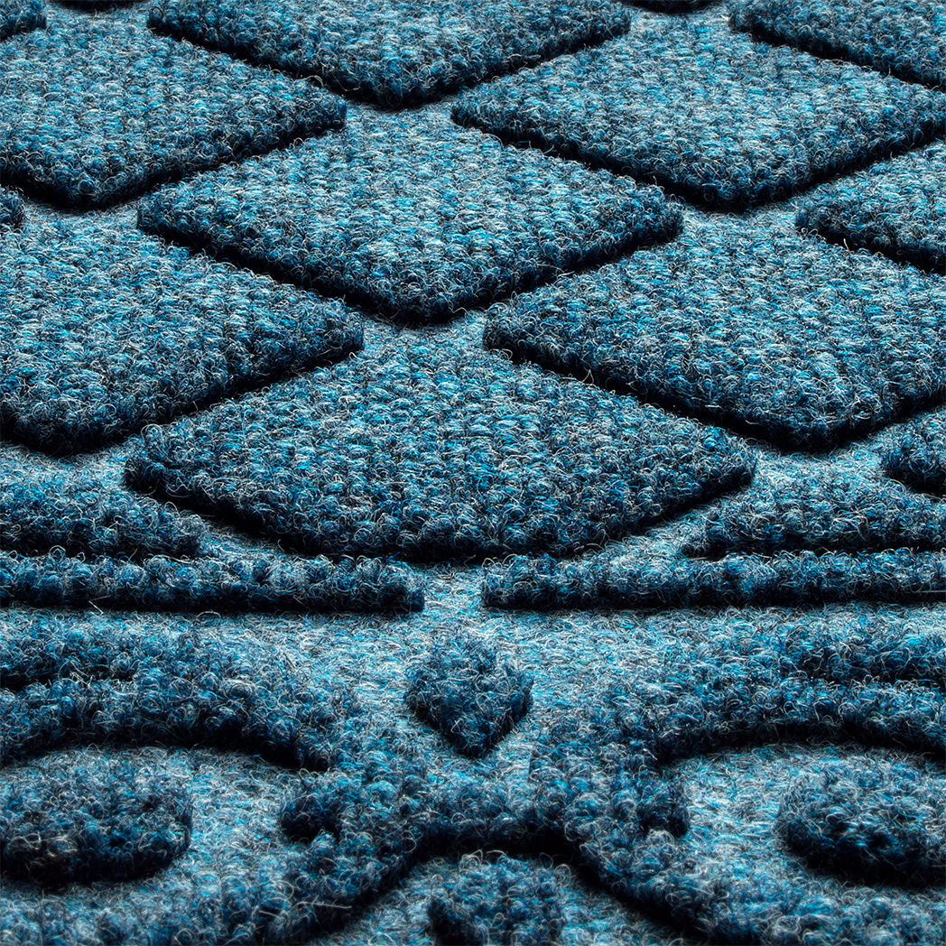 Detailed shot of WaterHog's Tristan doormat's bi-level surface, detailing the eco-friendly fibers of various blues, white, and grey, blending to make a fade-resistant, classic navy color.